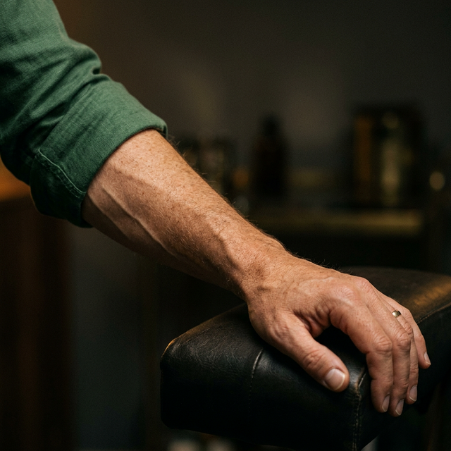 Man's forearm with visible veins, warm editorial lighting